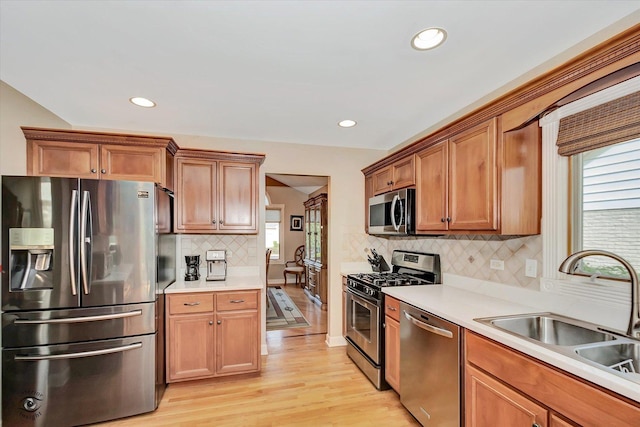 16313 Bob White Cir, Orland Park, IL 60467 - kitchen with stainless steel appliances, a sink, tasteful backsplash, light wood-style floors, and light countertops