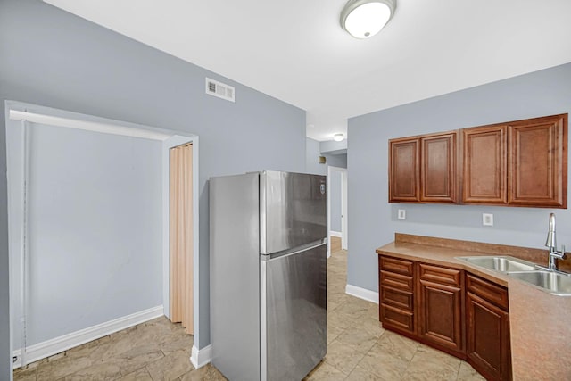 8407 S Throop St, Chicago, IL 60620 - kitchen with freestanding refrigerator, a sink, baseboards, light countertops, and brown cabinets
