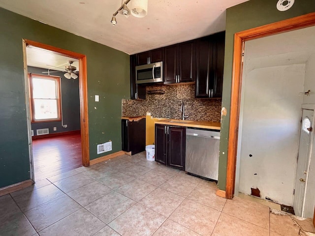 7304 W 57th St, Summit, IL 60501 - kitchen with appliances with stainless steel finishes, tasteful backsplash, light tile patterned floors, and light countertops