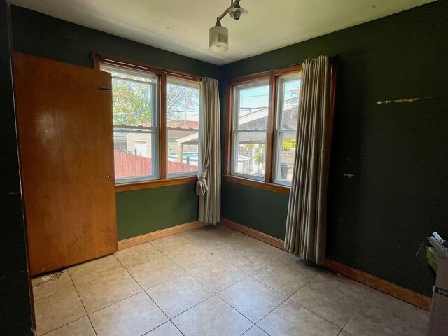 7304 W 57th St, Summit, IL 60501 - spare room with plenty of natural light, light tile patterned flooring, and baseboards