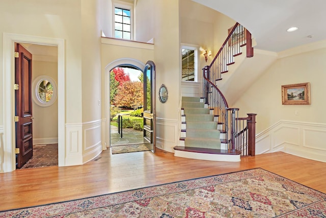 64 Ridge Rd, Barrington Hills, IL 60010 - foyer entrance featuring a decorative wall, wood finished floors, stairway, a wainscoted wall, and crown molding