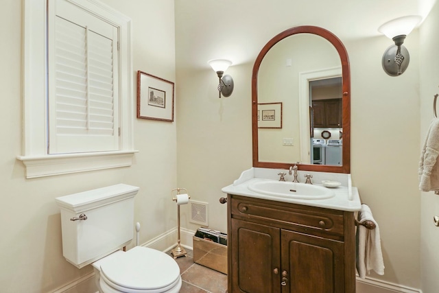 64 Ridge Rd, Barrington Hills, IL 60010 - bathroom with washing machine and dryer, toilet, vanity, baseboards, and tile patterned floors