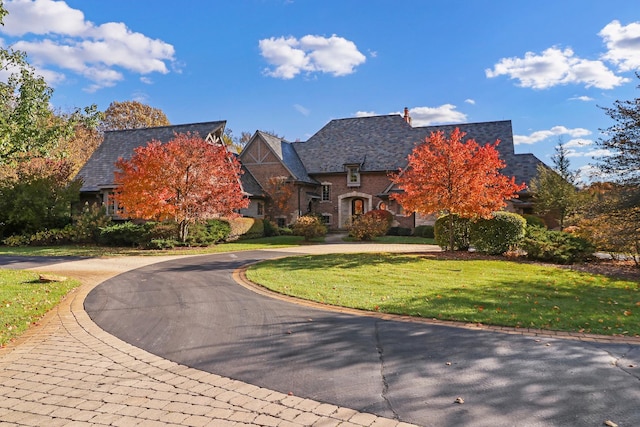 64 Ridge Rd, Barrington Hills, IL 60010 - view of front of home with curved driveway, a front lawn, a high end roof, and stone siding