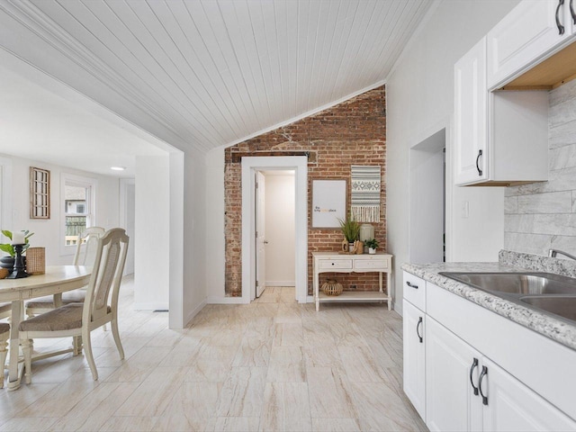 426 Reed St, Pecatonica, IL 61063 - kitchen with brick wall, a sink, vaulted ceiling, white cabinets, and wooden ceiling