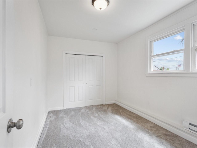 426 Reed St, Pecatonica, IL 61063 - unfurnished bedroom with carpet flooring, a closet, baseboards, and a baseboard radiator