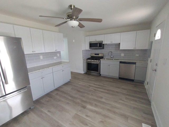 615 Hamrick Ave, Romeoville, IL 60446 - kitchen featuring stainless steel appliances, a sink, decorative backsplash, a ceiling fan, and white cabinets