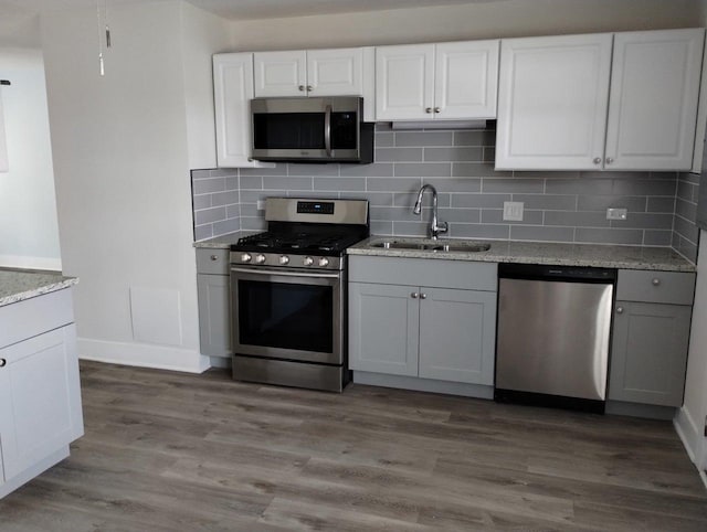 615 Hamrick Ave, Romeoville, IL 60446 - kitchen featuring appliances with stainless steel finishes, a sink, backsplash, and white cabinets