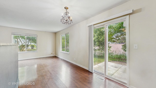 733 Fieldcrest Dr Unit A, South Elgin, IL 60177 - unfurnished room featuring a chandelier, wood finished floors, and baseboards