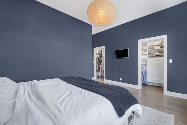 3056 N Monticello Ave, Chicago, IL 60618 - bedroom with a walk in closet, wood finished floors, baseboards, and a closet