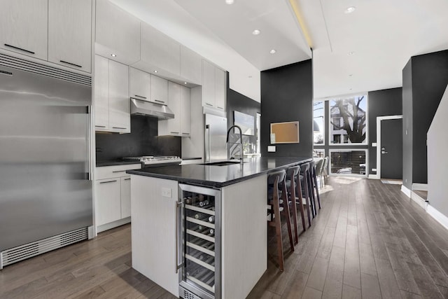 3056 N Monticello Ave, Chicago, IL 60618 - kitchen featuring stainless steel built in refrigerator, beverage cooler, a sink, under cabinet range hood, and dark wood-style floors