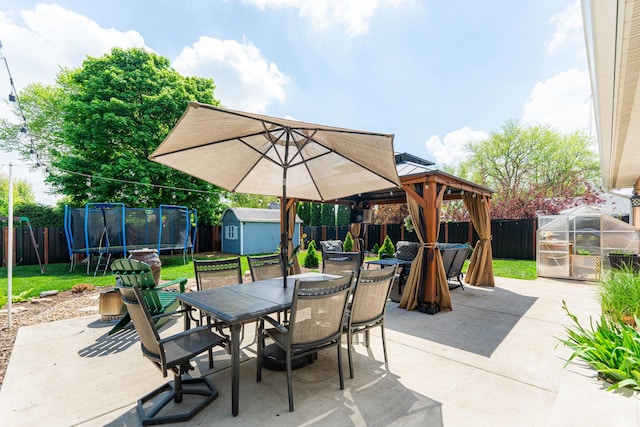 854 Meadow Ln, Sycamore, IL 60178 - view of patio / terrace with a trampoline, outdoor dining space, a storage shed, an outbuilding, and a gazebo