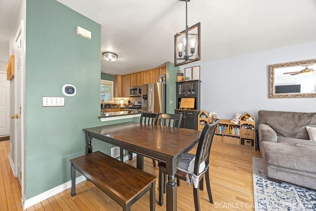 1653 W Ethans Glen Dr, Palatine, IL 60067 - dining space with light wood finished floors, a chandelier, and baseboards