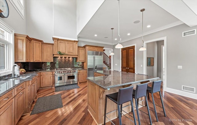 7N627 E Drive S, Elgin, IL 60177 - kitchen with high end appliances, a sink, wood finished floors, tasteful backsplash, and recessed lighting