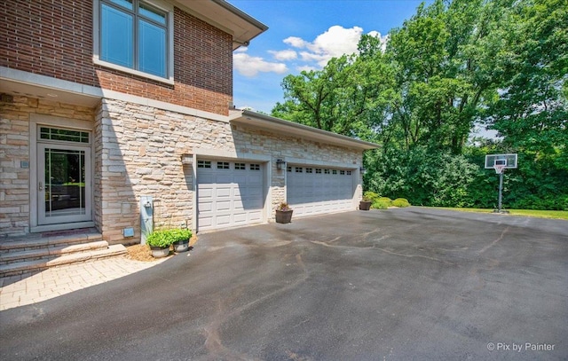 7N627 E Drive S, Elgin, IL 60177 - view of property exterior featuring stone siding, asphalt driveway, and entry steps