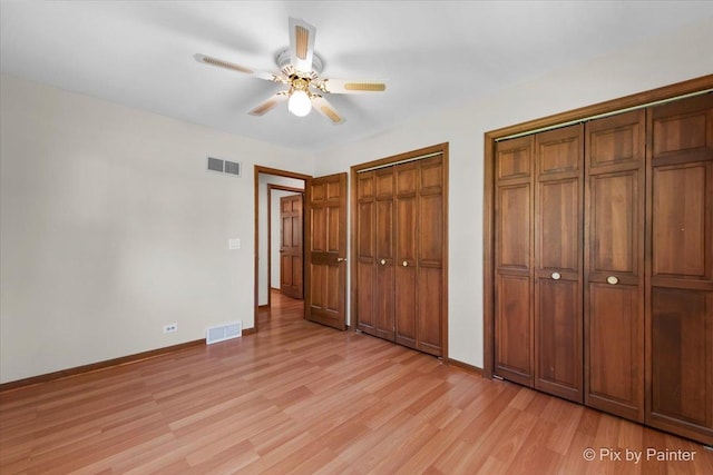 7N627 E Drive S, Elgin, IL 60177 - unfurnished bedroom featuring light wood-style floors, two closets, baseboards, and a ceiling fan