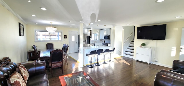 5644 Lyons St, Morton Grove, IL 60053 - living room featuring decorative columns, recessed lighting, stairs, ornamental molding, and dark wood-style flooring