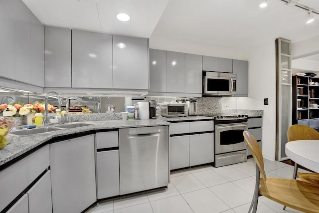 1440 N Lake Shore Dr Unit 4Bd, Chicago, IL 60610 - kitchen featuring stainless steel appliances, gray cabinetry, decorative backsplash, light stone counters, and light tile patterned floors