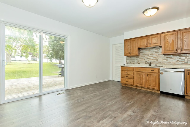 1708 Meadow Ln, Mchenry, IL 60050 - kitchen with stainless steel dishwasher, light countertops, tasteful backsplash, and dark wood-type flooring