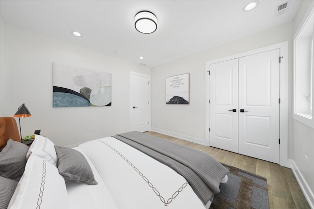 bedroom with light wood-style flooring, recessed lighting, a closet, and baseboards