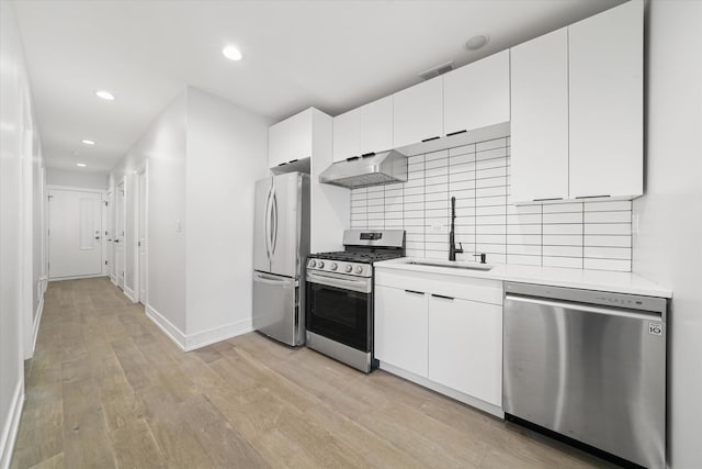 kitchen featuring stainless steel appliances, a sink, extractor fan, light countertops, and backsplash