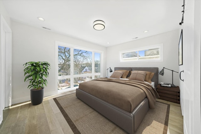 bedroom featuring light wood finished floors, recessed lighting, and baseboards