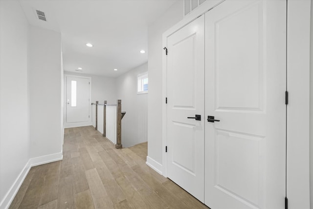 hallway featuring light wood finished floors, recessed lighting, and baseboards
