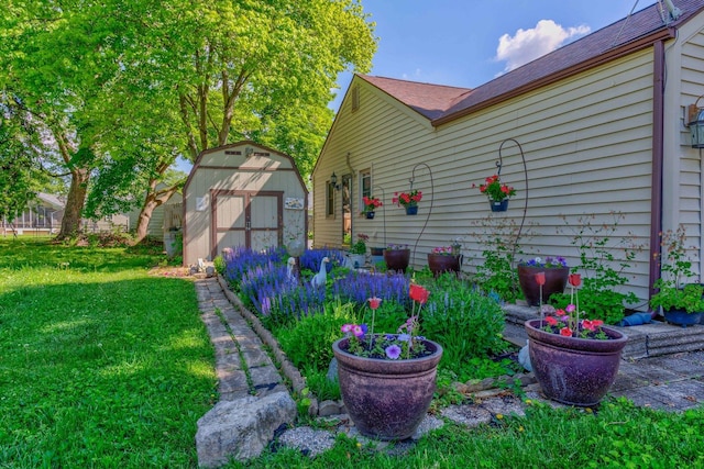 606 E Houghton St, Tuscola, IL 61953 - view of home's exterior featuring a storage shed, an outbuilding, a lawn, and roof with shingles