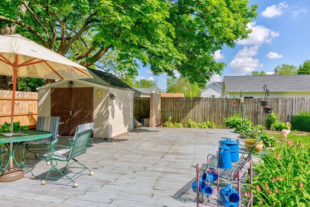 606 E Houghton St, Tuscola, IL 61953 - view of patio with a storage unit, a fenced backyard, an outbuilding, and a wooden deck