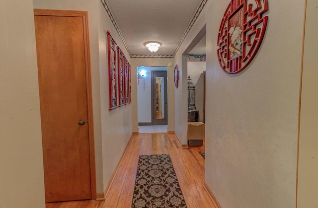 606 E Houghton St, Tuscola, IL 61953 - corridor featuring a textured ceiling, light wood-style floors, and crown molding