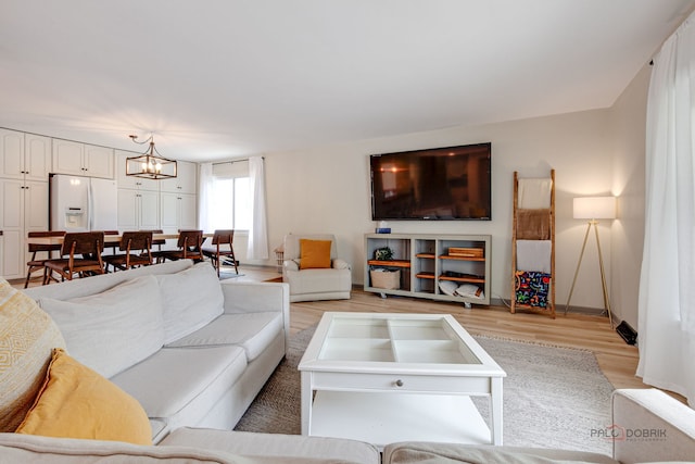 5045 S Rd, Gurnee, IL 60031 - living area featuring light wood finished floors, a chandelier, and baseboards
