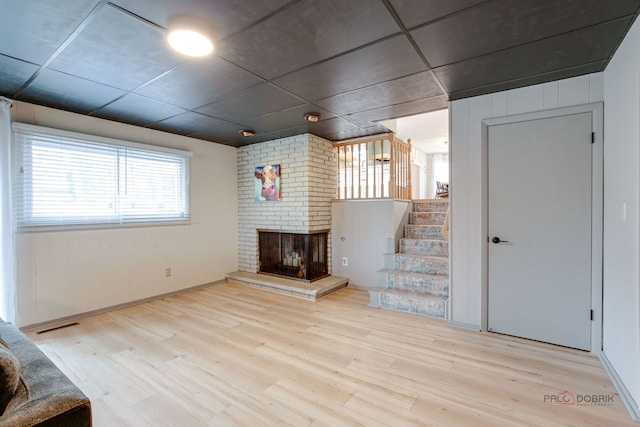 5045 S Rd, Gurnee, IL 60031 - unfurnished living room featuring wood finished floors, a brick fireplace, stairway, and baseboards