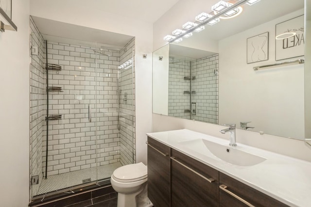 bathroom featuring a stall shower, toilet, and vanity