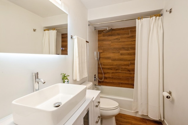 full bath featuring shower / bath combo, toilet, wood finished floors, and vanity