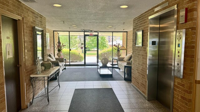 community lobby featuring brick wall, expansive windows, and recessed lighting