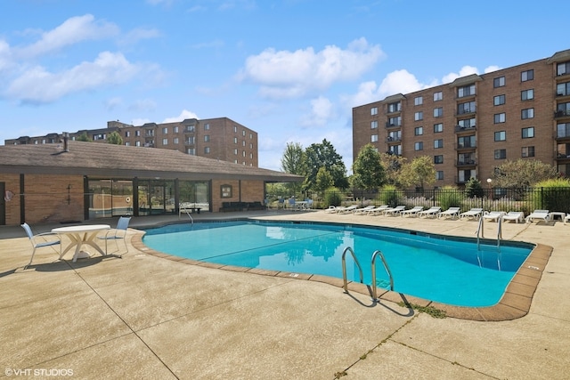 community pool with fence and a patio