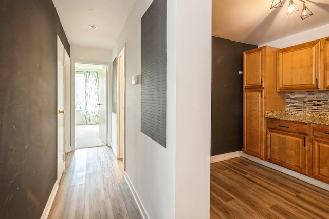 hallway with wood finished floors and baseboards