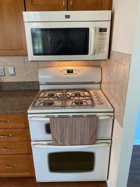 950 Arlon Rd, Aurora, IL 60506 - kitchen view of white appliances, brown cabinetry, and tasteful backsplash