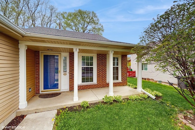 618 Hampton Cir, Elgin, IL 60120 - property entrance with a yard, brick siding, roof with shingles, and covered porch
