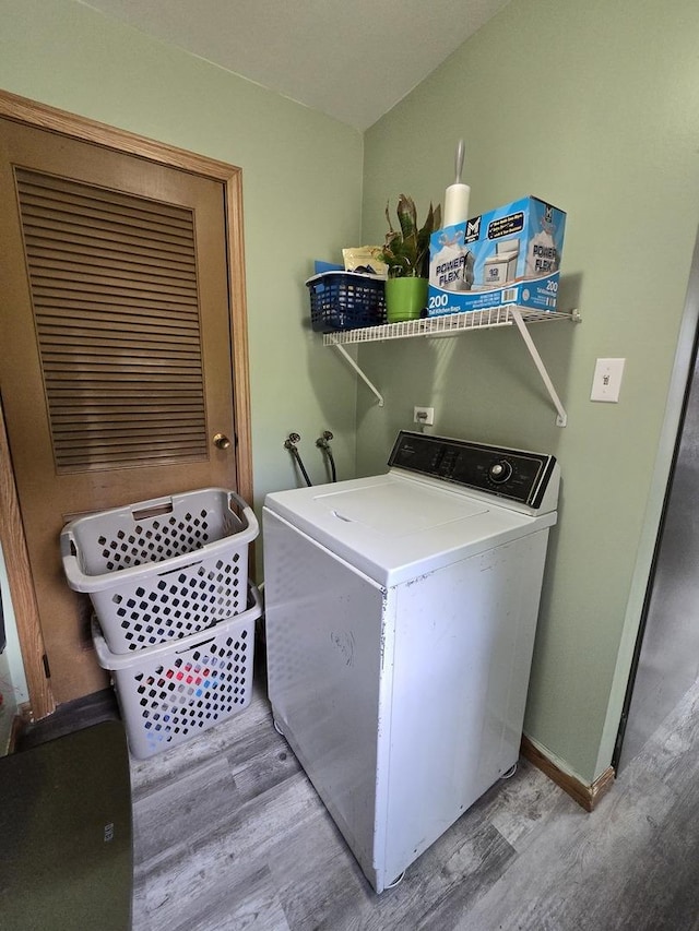 washroom featuring washer / clothes dryer, light wood finished floors, and baseboards