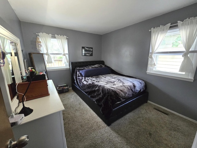 bedroom with multiple windows, carpet flooring, and baseboards