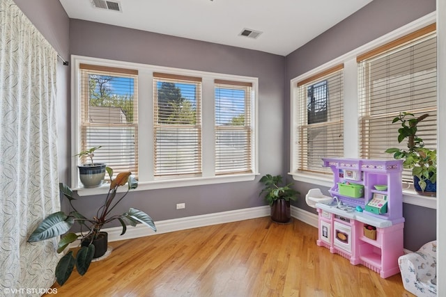 playroom with baseboards and wood finished floors