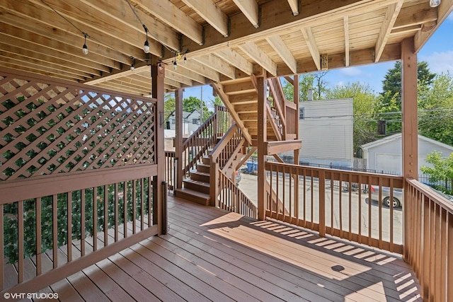 wooden terrace featuring stairway and an outbuilding