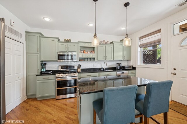 3515 W Medill Ave Unit 1W, Chicago, IL 60647 - kitchen with green cabinets, appliances with stainless steel finishes, a sink, tasteful backsplash, and recessed lighting