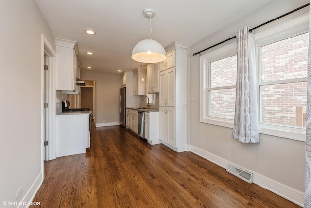 8128 N Odell Ave, Niles, IL 60714 - kitchen featuring appliances with stainless steel finishes, a sink, white cabinetry, baseboards, and dark wood-type flooring