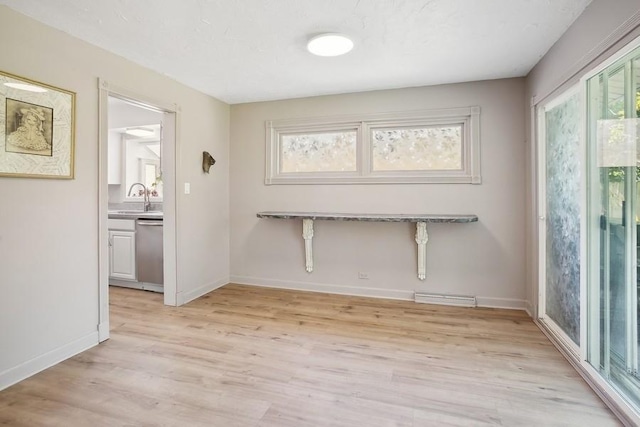735 Lamon Ave, Wilmette, IL 60091 - unfurnished dining area featuring healthy amount of natural light, light wood-type flooring, a sink, and baseboards