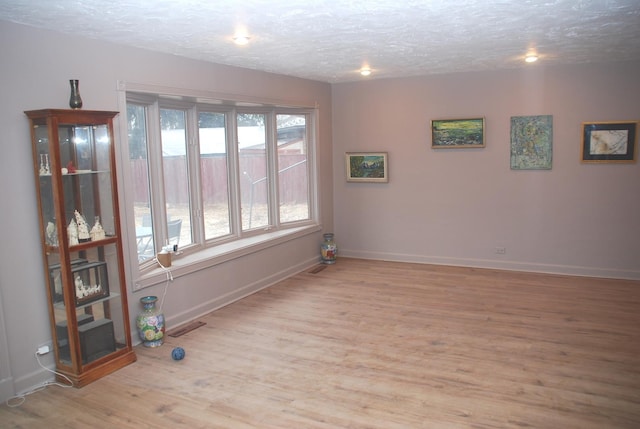 735 Lamon Ave, Wilmette, IL 60091 - spare room featuring a textured ceiling, baseboards, and wood finished floors
