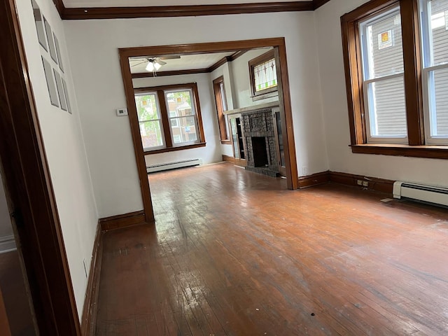 3423 N Tripp Ave, Chicago, IL 60641 - unfurnished living room featuring crown molding, baseboard heating, hardwood / wood-style flooring, baseboards, and a fireplace with raised hearth