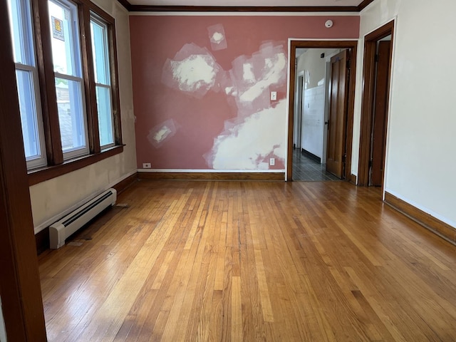 3423 N Tripp Ave, Chicago, IL 60641 - empty room with a baseboard heating unit, crown molding, wood-type flooring, and baseboards