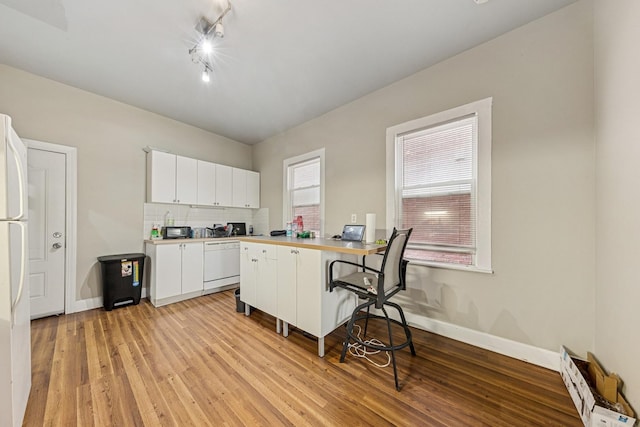 2443 N Marshfield Ave, Chicago, IL 60614 - kitchen with white appliances, a kitchen bar, white cabinetry, baseboard heating, and light wood-type flooring