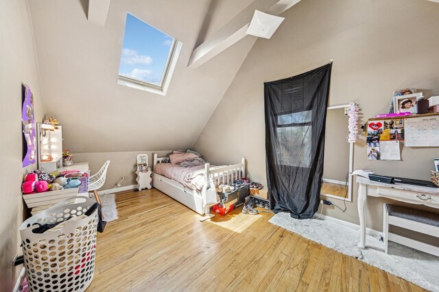 2443 N Marshfield Ave, Chicago, IL 60614 - bedroom featuring wood finished floors, lofted ceiling, a skylight, and baseboards